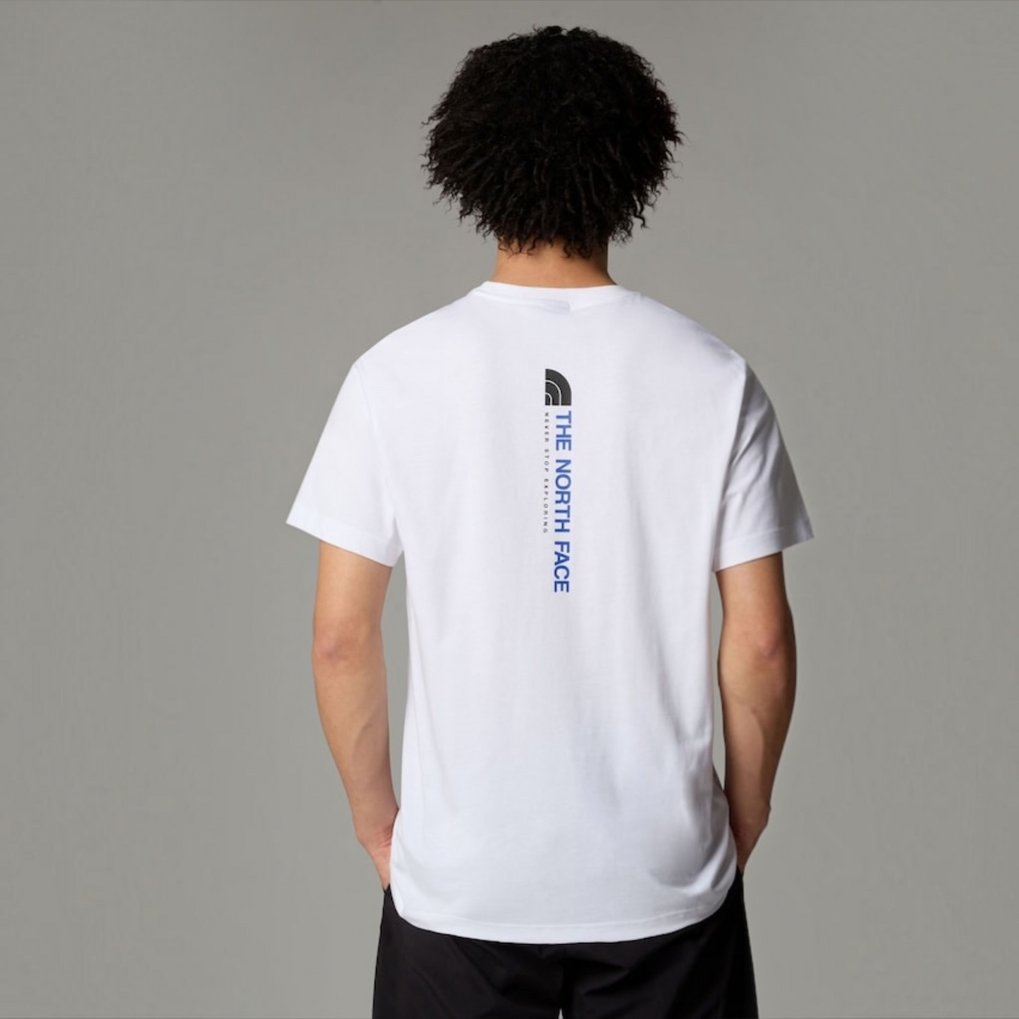 The North Face men’s white Vertical Logo T-shirt with blue and black back graphic and Never Stop Exploring slogan
